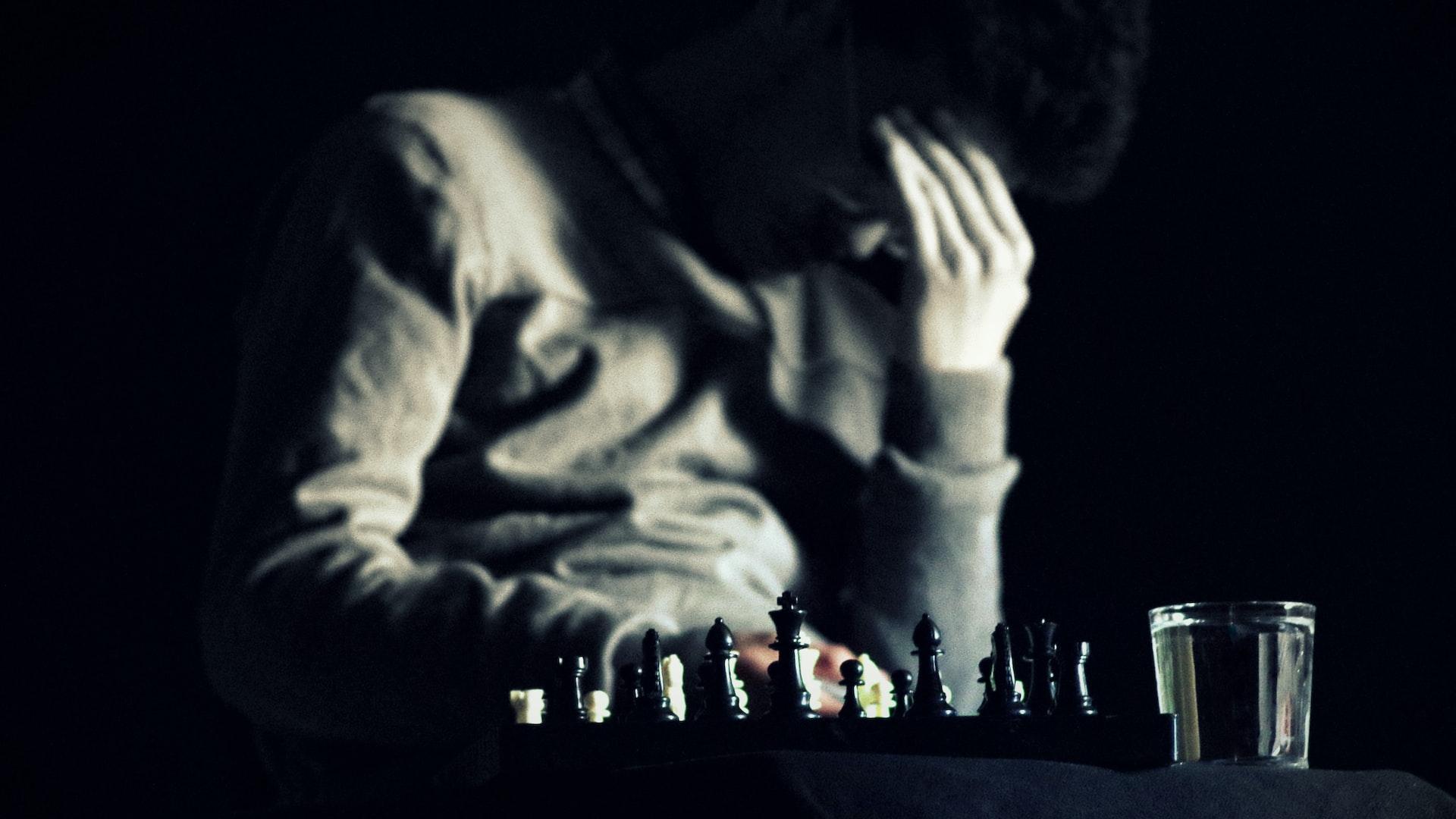 a man sitting at a table with a chess board